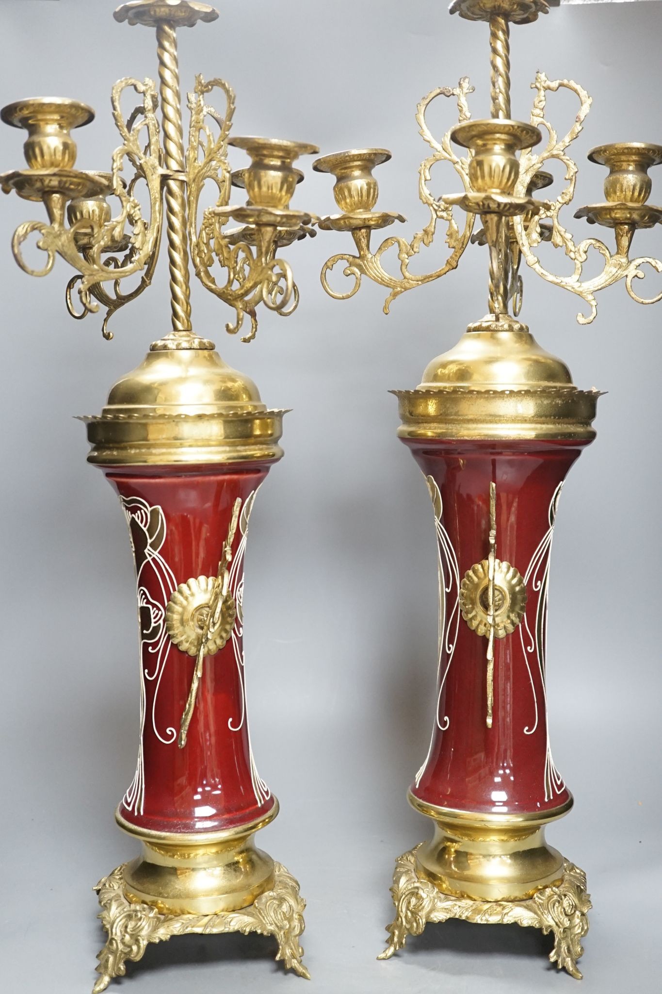 A pair of large brass and ceramic mounted candelabra, 64.5 cms high.